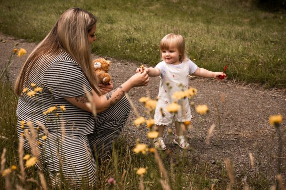 Inniges Mutter-Kind-Shooting in Kassel beim Verschenken einer Blüte.