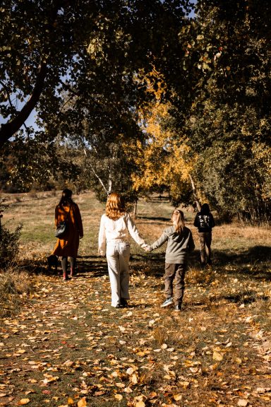 Natürliches Familien-Fotoshooting in Kassel - Familie geht Hand in Hand bei einem Spaziergang im Freien.